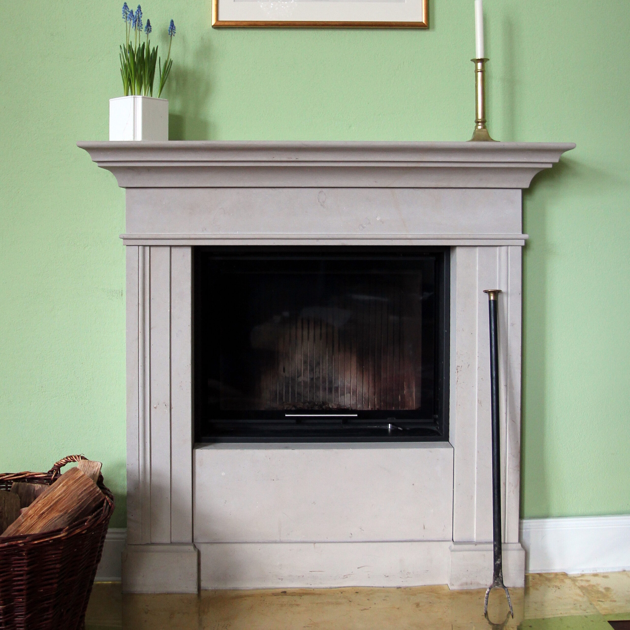 Steinkamin mit schlichtem Profil in einem Wohnzimmer.